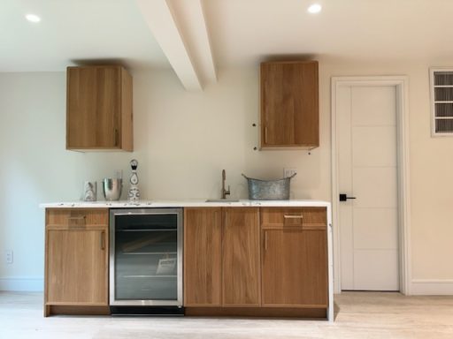 Modern kitchen with wooden cabinetry, a marble countertop, and stainless steel appliances.