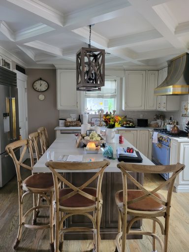 Bright kitchen featuring a central island with bar stools and a variety of colorful ingredients.