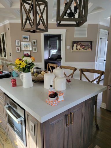 Bright kitchen with a central island, flowers, and decorative items on the countertop.