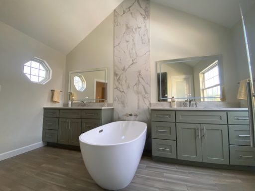 Modern bathroom featuring a freestanding tub, dual sinks, and large mirrors.