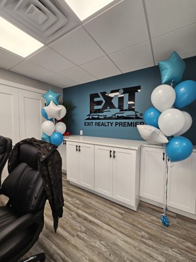 Office setting with blue and white balloons near a modern logo wall.