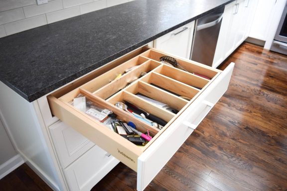 Open kitchen drawer organized with various tools and utensils.