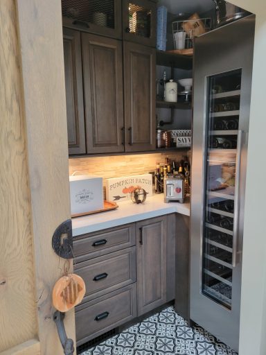 Cozy kitchen corner with dark wood cabinets and a wine fridge.